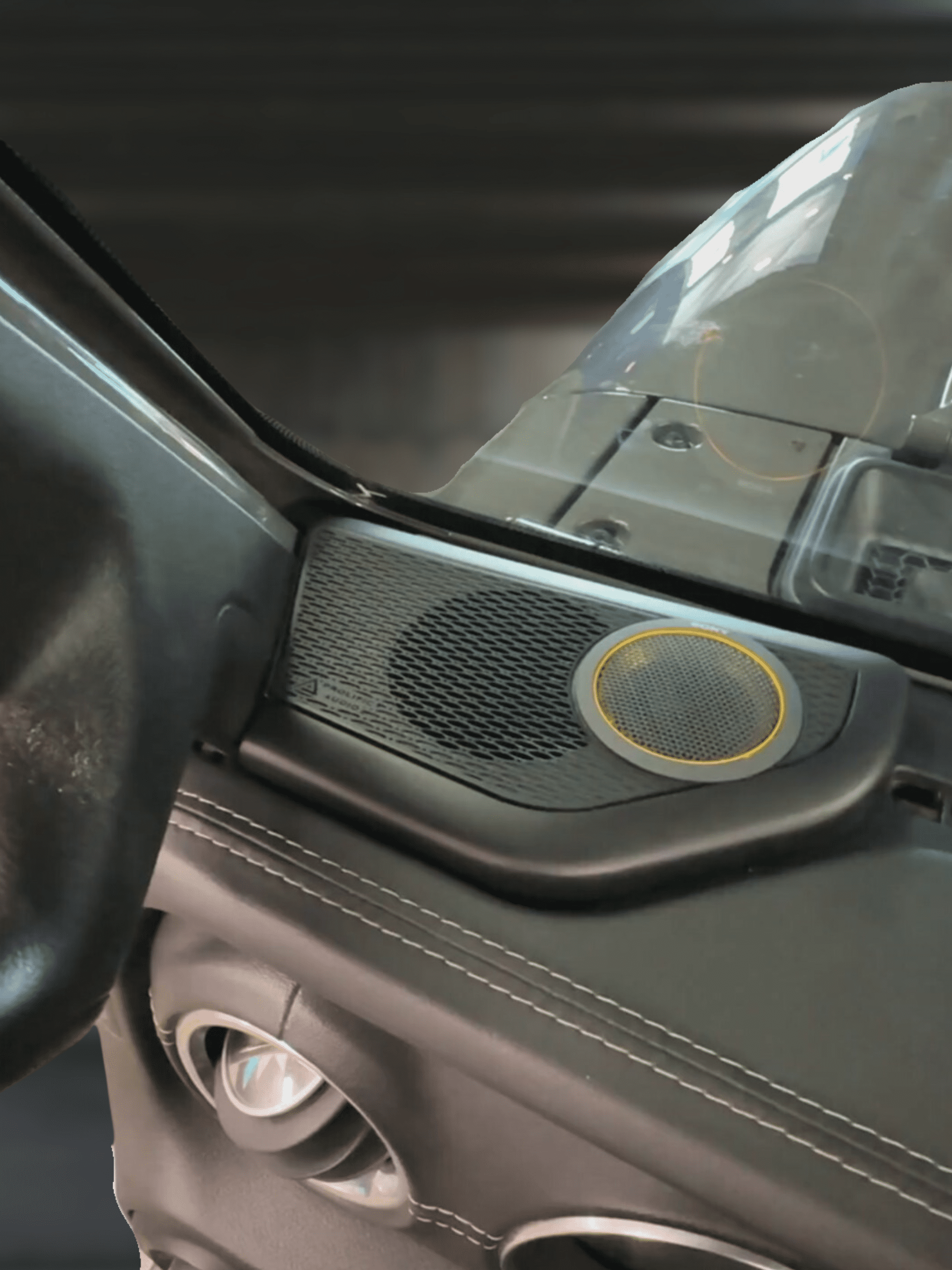 Tweeter pod installed in a Jeep JL JT vehicle, featuring a black mesh design and a circular speaker element.